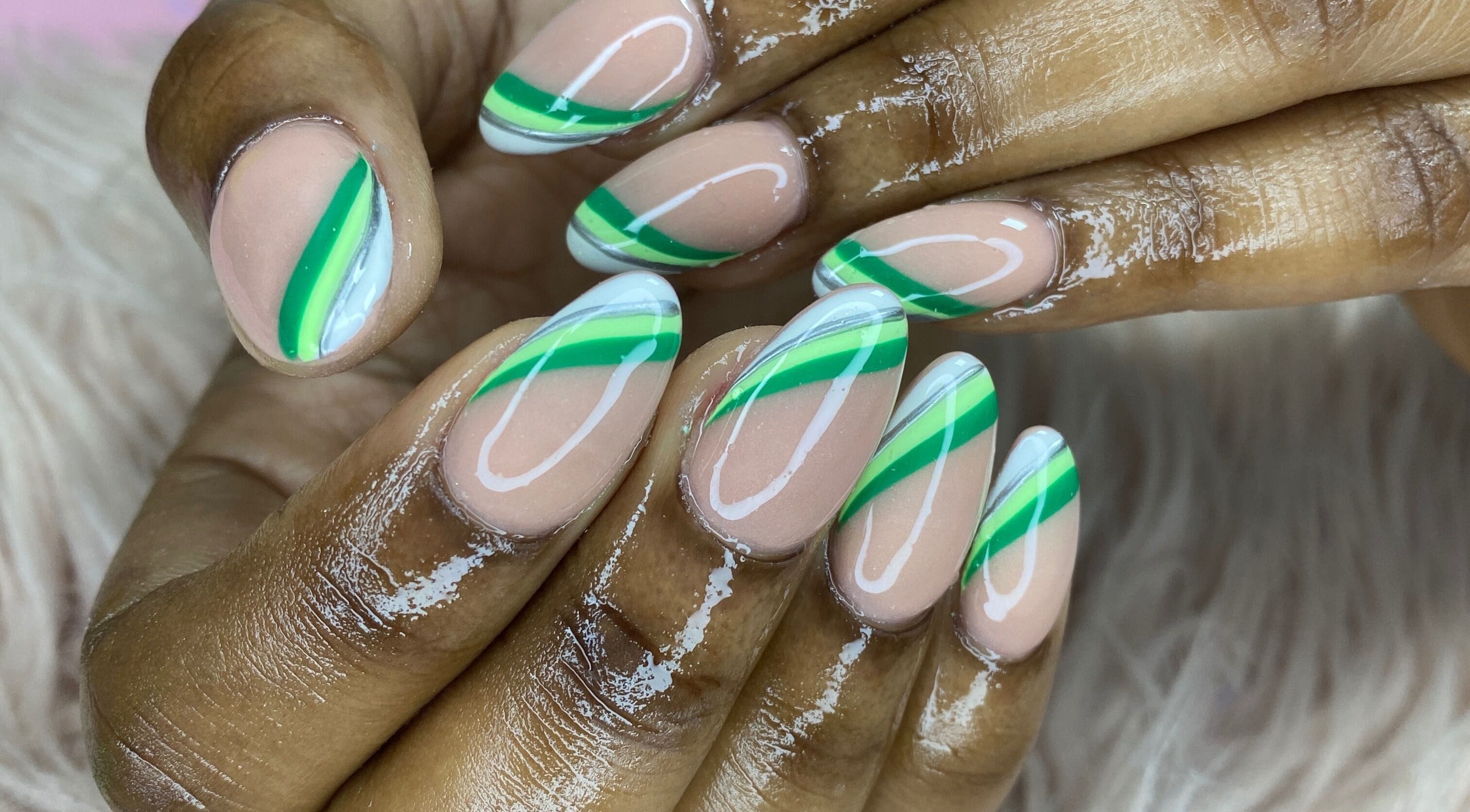 Almond-shaped nails with green stripes by K’ Oari Nail Artistry in Potters Village, Saint John, AG.