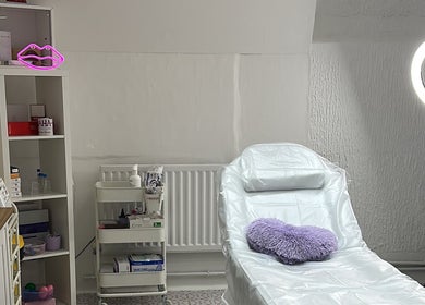 Aesthetic treatment room at Maha Aesthetics Clinic in London, England, GB featuring a cozy chair and soft lighting.