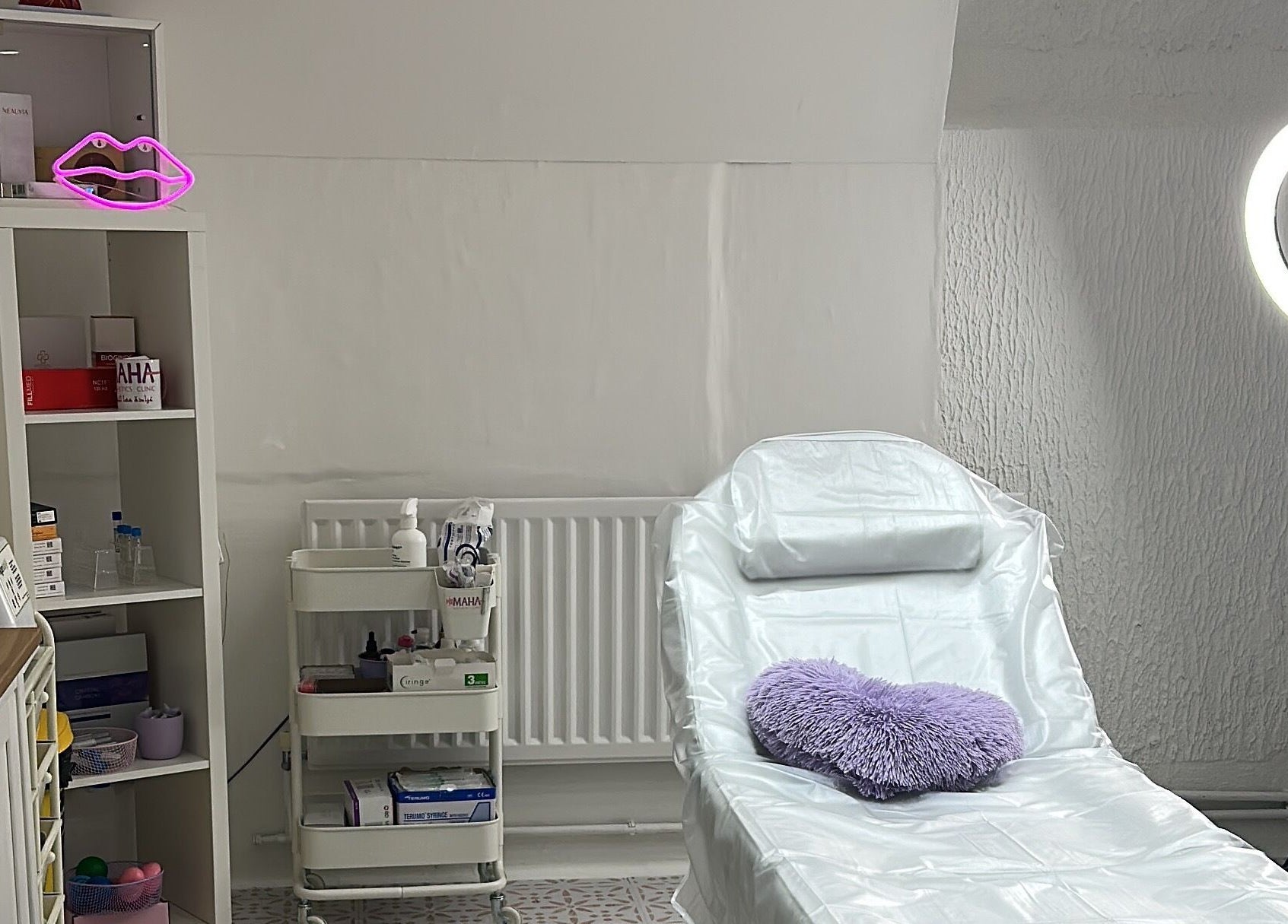 Aesthetic treatment room at Maha Aesthetics Clinic in London, England, GB featuring a cozy chair and soft lighting.