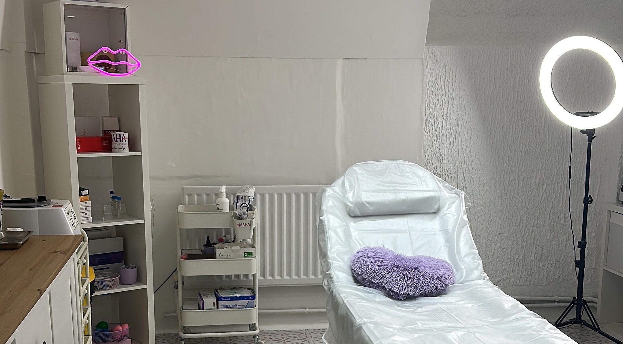 Aesthetic treatment room at Maha Aesthetics Clinic in London, England, GB featuring a cozy chair and soft lighting.