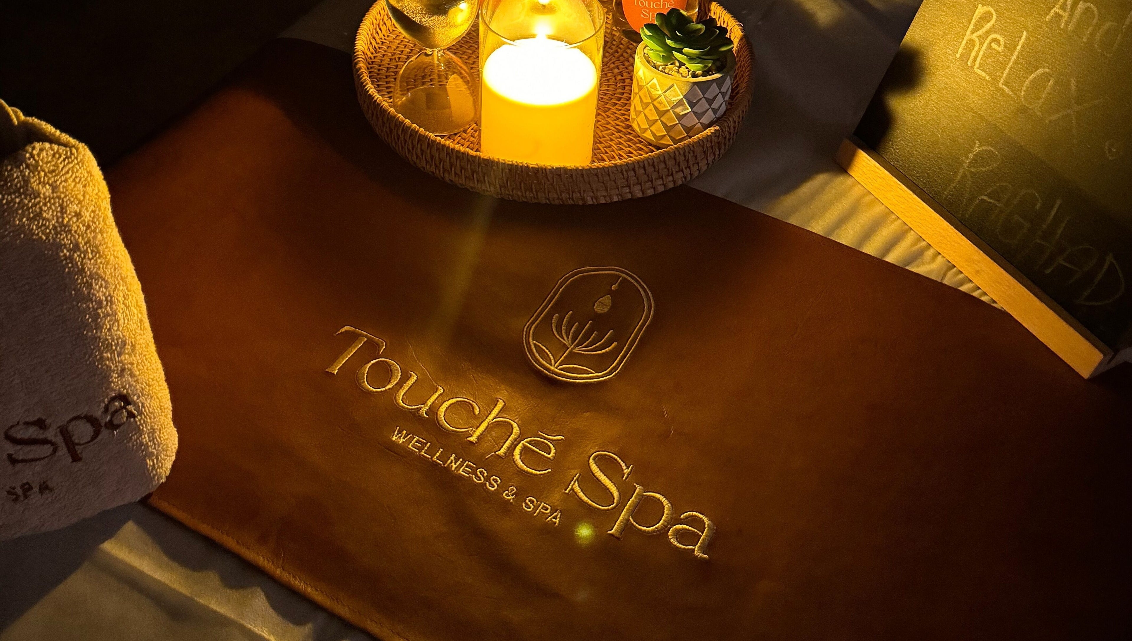 Touché Spa | Home Service ambiance with candle and towel in Jeddah, Makkah Province, SA.