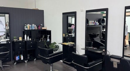 Modern hairstyling area at Oxenford Hair & Beauty, Oxenford, Queensland, AU with black salon chairs and mirrors.