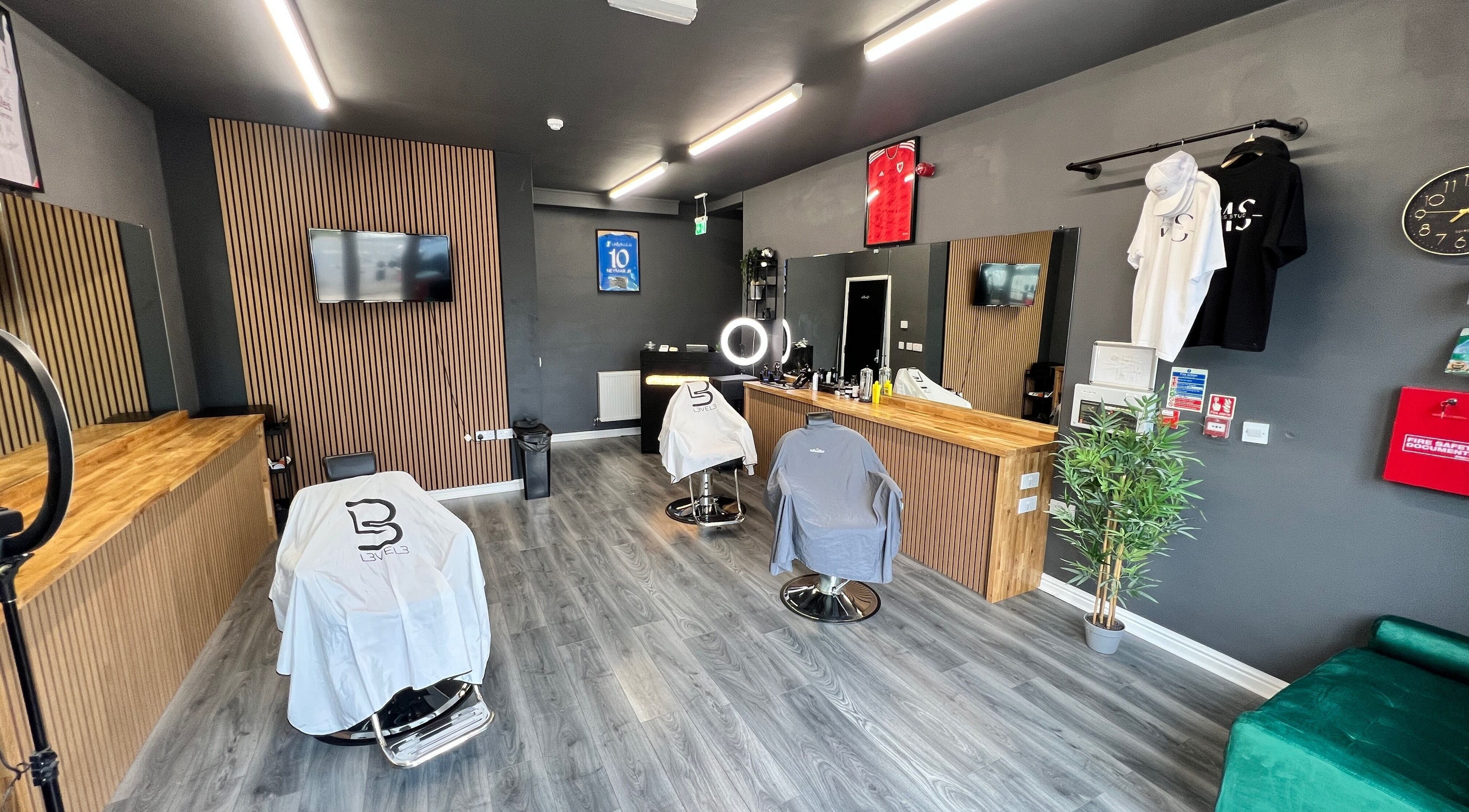 Modern Moss Barber Studio interior in Llantrisant, Wales, GB with sleek styling stations and mirror lighting.