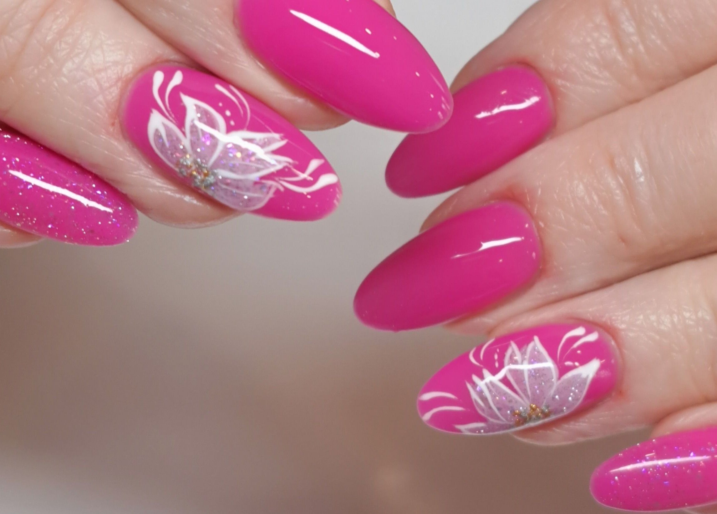 Stunning pink floral nail art at MB Beauty Nails, Spalding, England, GB, featuring delicate white flowers.