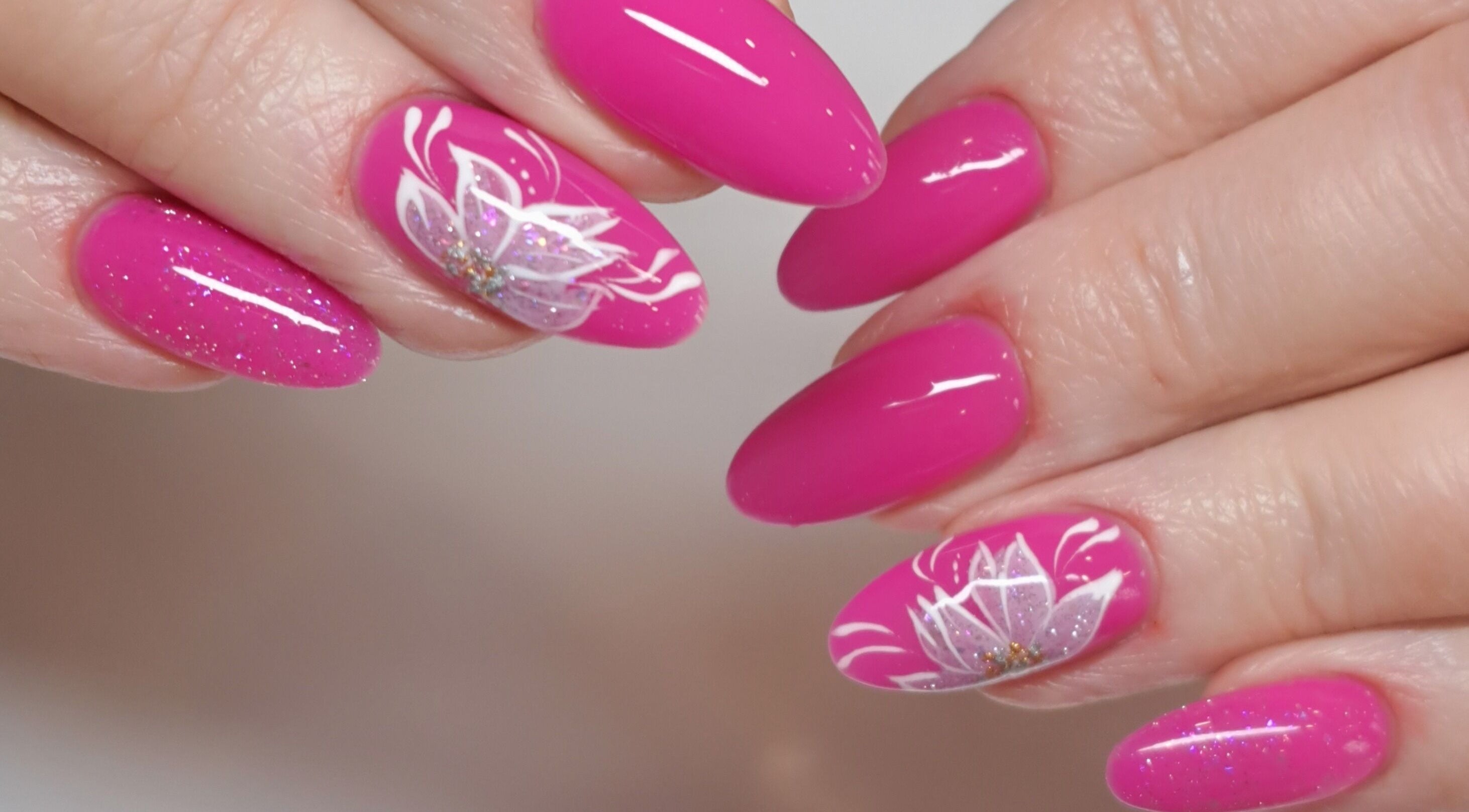 Stunning pink floral nail art at MB Beauty Nails, Spalding, England, GB, featuring delicate white flowers.
