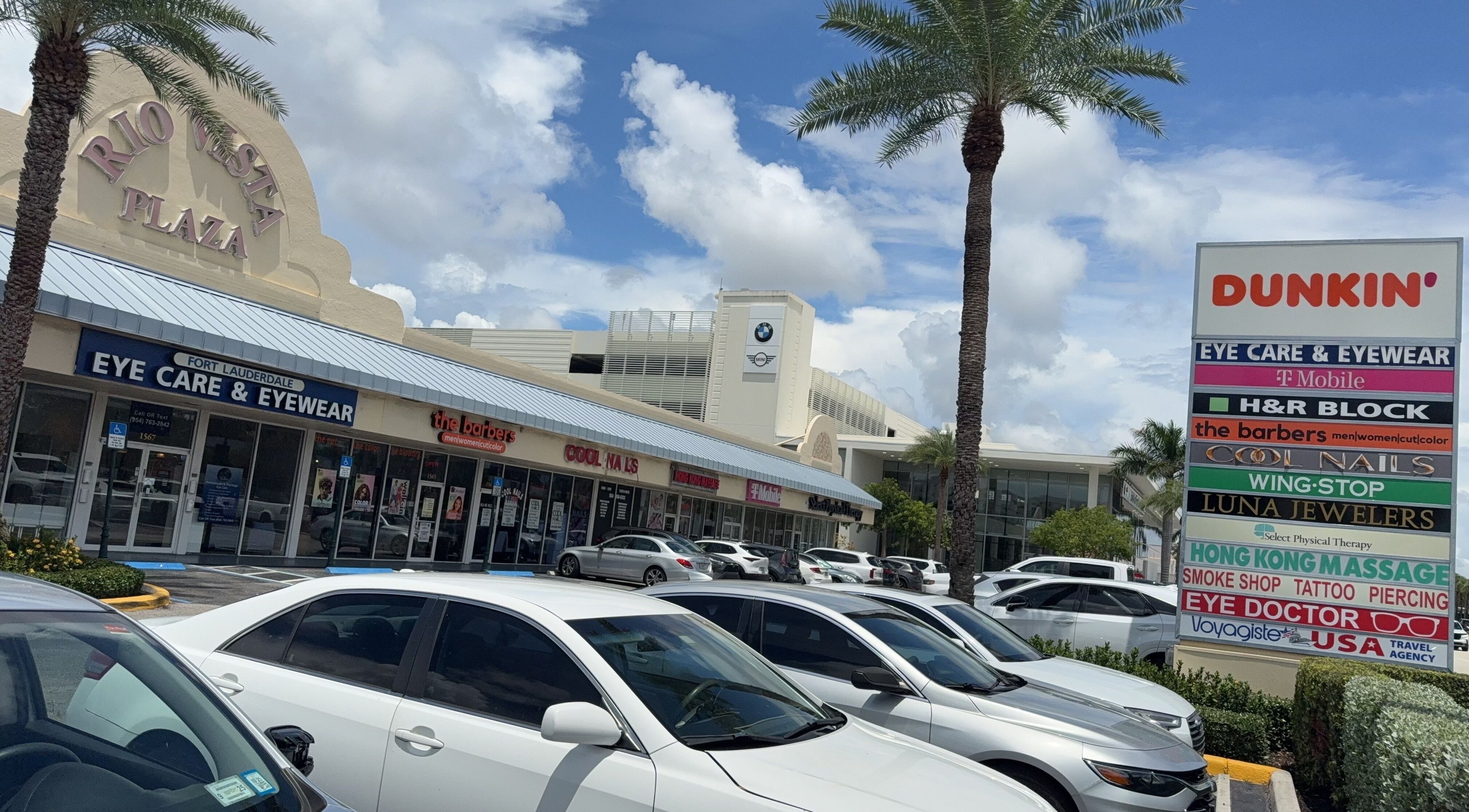 Shopping plaza in Fort Lauderdale, Florida with Hong Kong Massage prominently displayed among various shops.