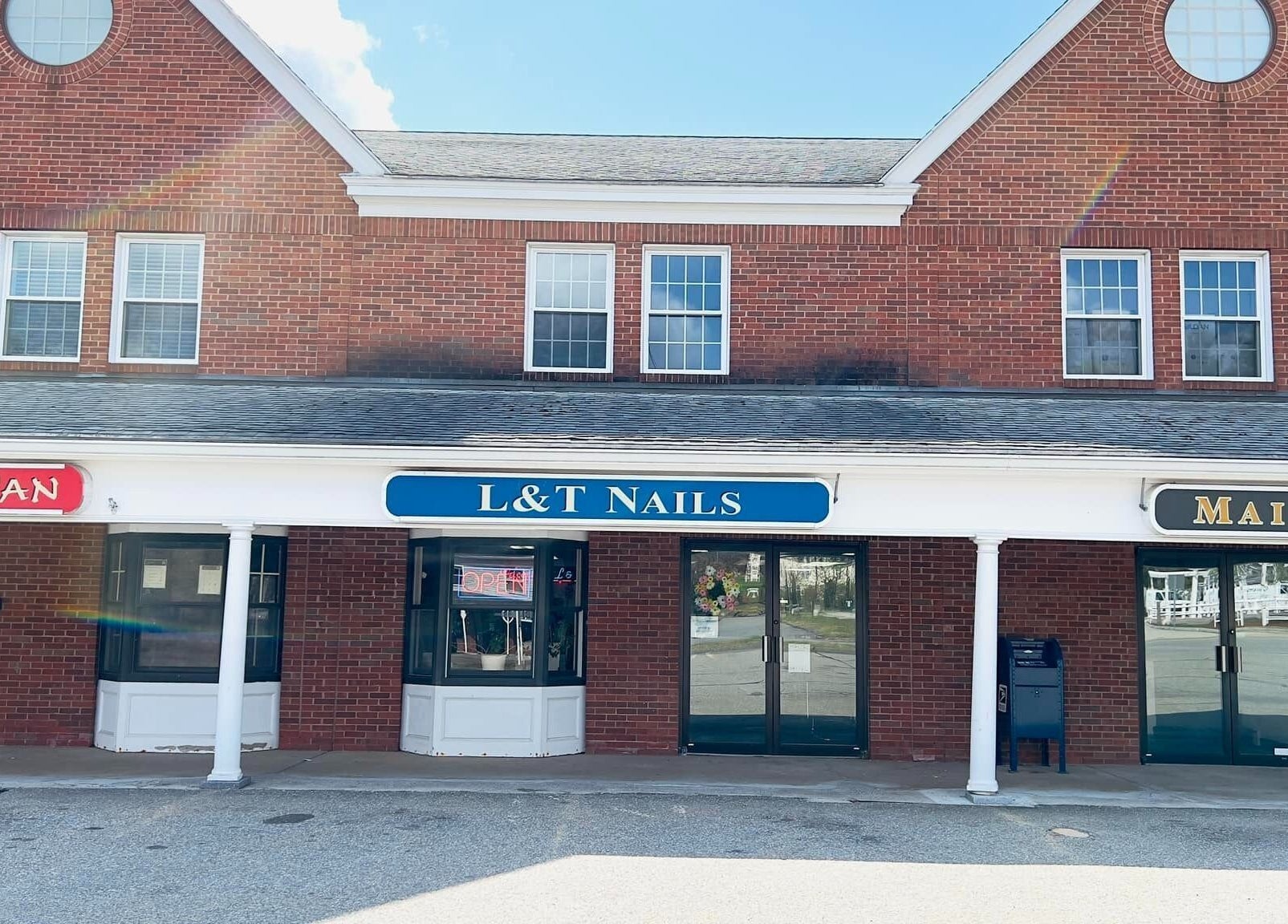 Front view of L & T Nails Salon at Northborough, Massachusetts, US with red brick exterior.