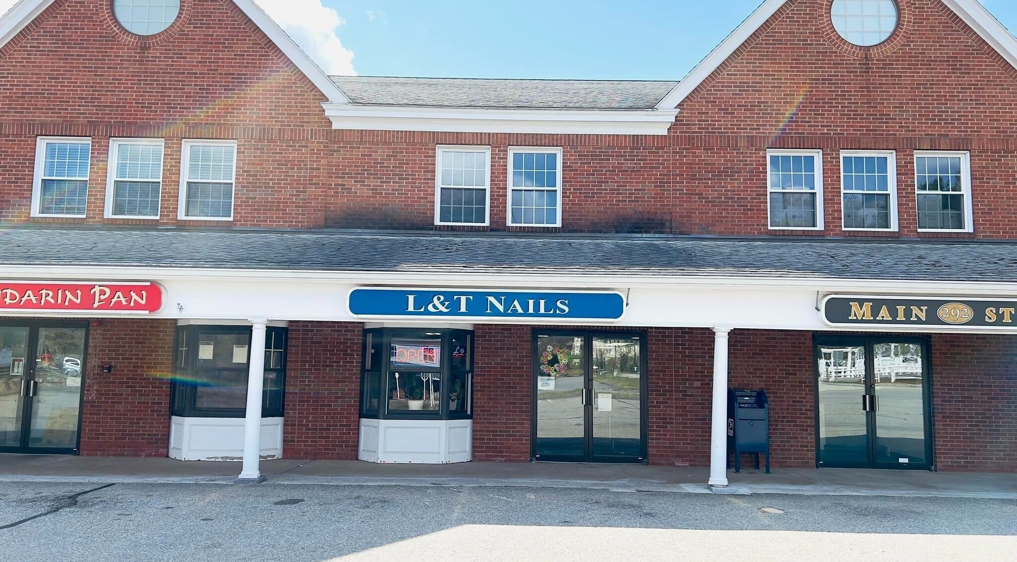 Front view of L & T Nails Salon at Northborough, Massachusetts, US with red brick exterior.