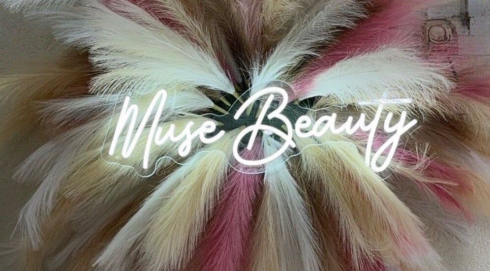 Elegant sign at Muse Beauty Artistry in Georgetown, Demerara-mahaica, GY, adorned with artistic feathers.