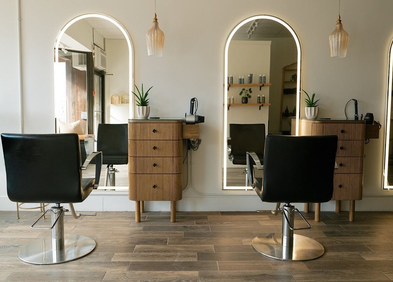Modern interior of Glow Hair Studio in Thorold, Ontario, CA, featuring chic styling chairs and mirrors.