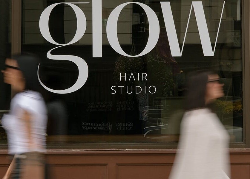 Front view of Glow Hair Studio in Thorold, Ontario, CA with elegant window signage.