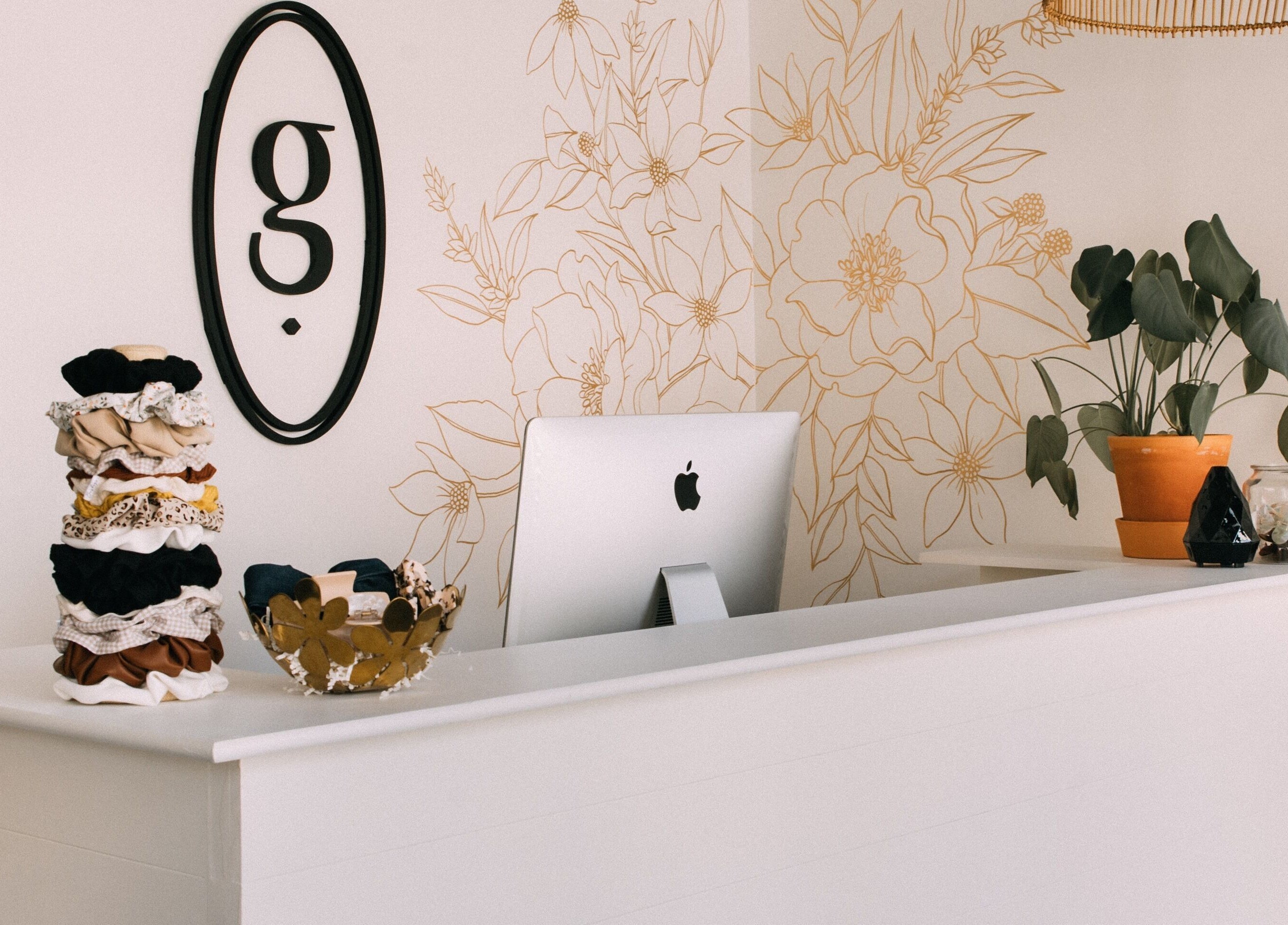Reception desk at Glow Hair Studio, Thorold, Ontario, with wall art and decor.