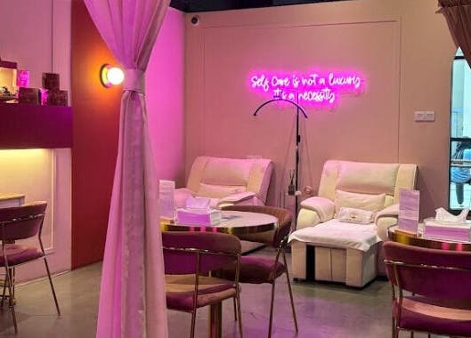 The Ruumah Spa Signature in Petaling Jaya, Selangor, MY features a cozy seating area with calming pink lighting.