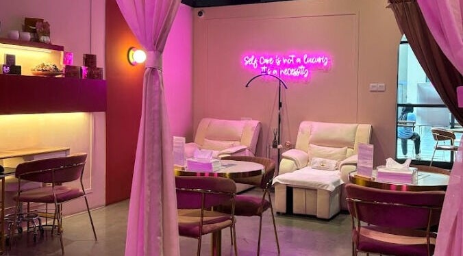 The Ruumah Spa Signature in Petaling Jaya, Selangor, MY features a cozy seating area with calming pink lighting.