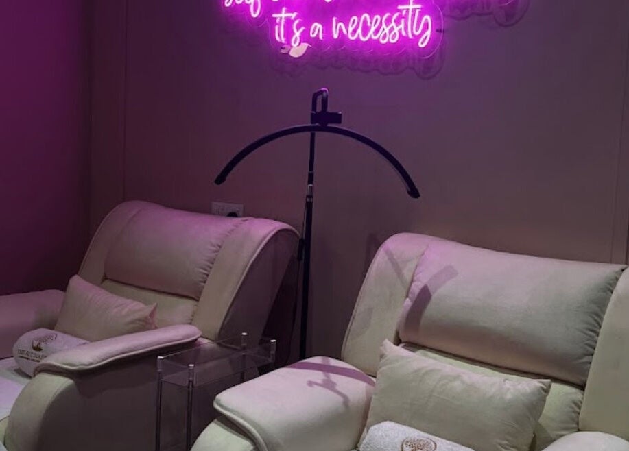 Luxurious massage chairs in The Ruumah Spa Signature, Petaling Jaya, Selangor, MY, under vibrant pink lighting.