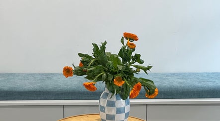 Vibrant orange flowers in a checkered vase at Wellness on William Street, Woolloomooloo, New South Wales, AU.