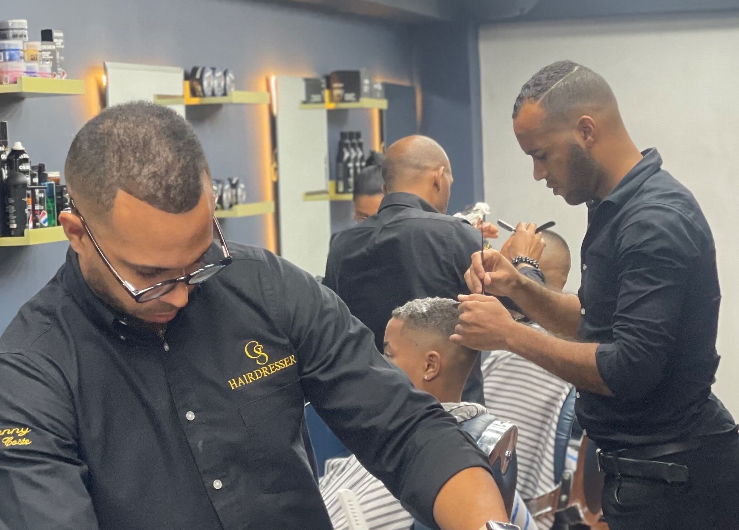 Estilista de GS Hairdresser Santo Domingo ofrece corte preciso en salón elegante.