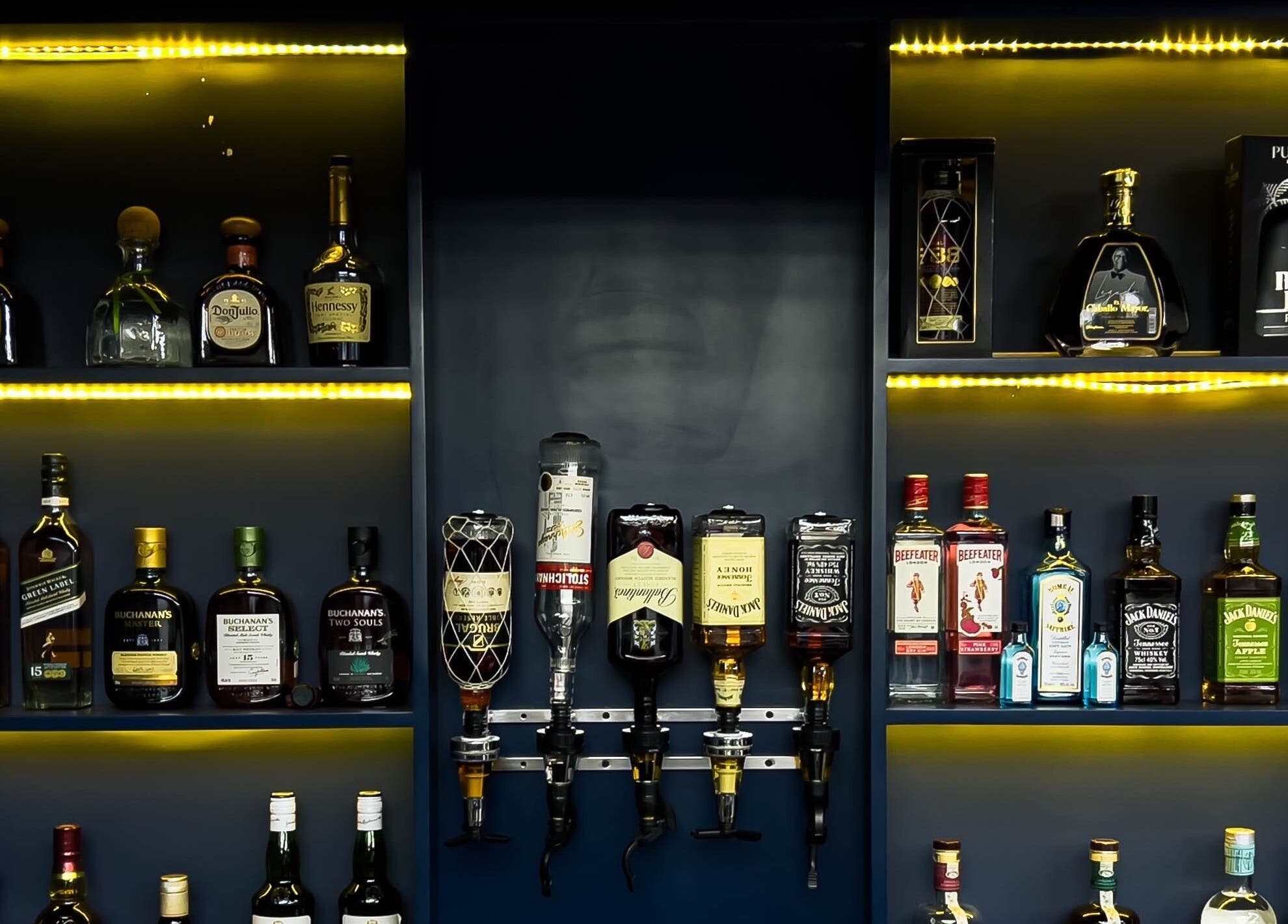Selección de licores en GS Hairdresser, Santo Domingo, Distrito Nacional, DO, con iluminación acogedora.