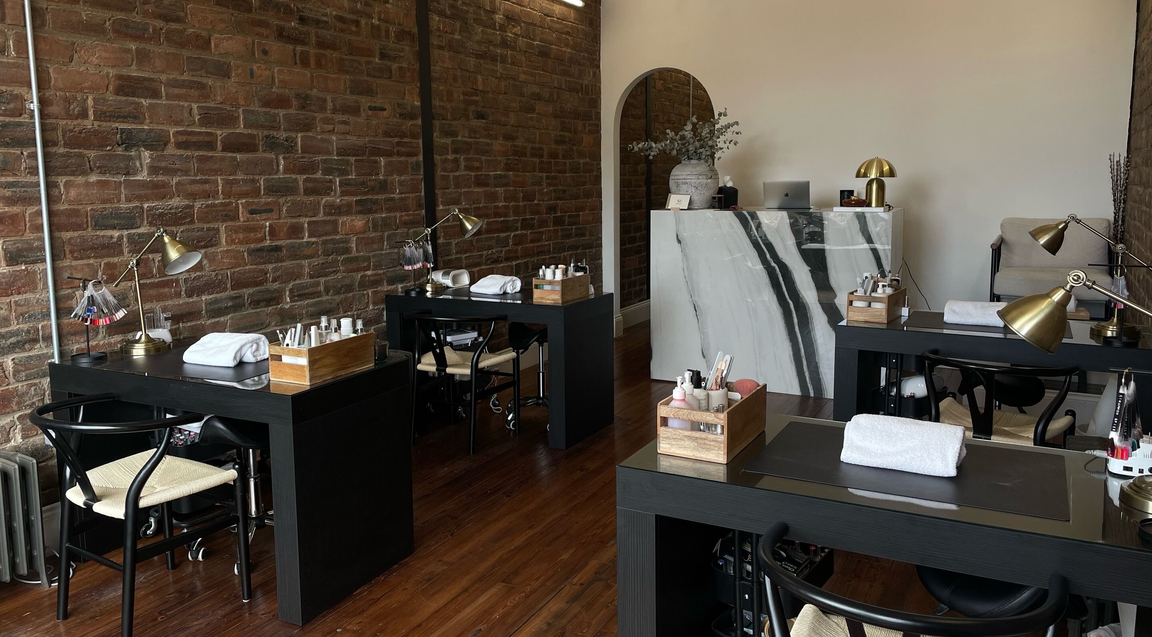 Modern beauty salon interior at Sò, Glasgow, Scotland, GB with stylish decor and manicure stations.