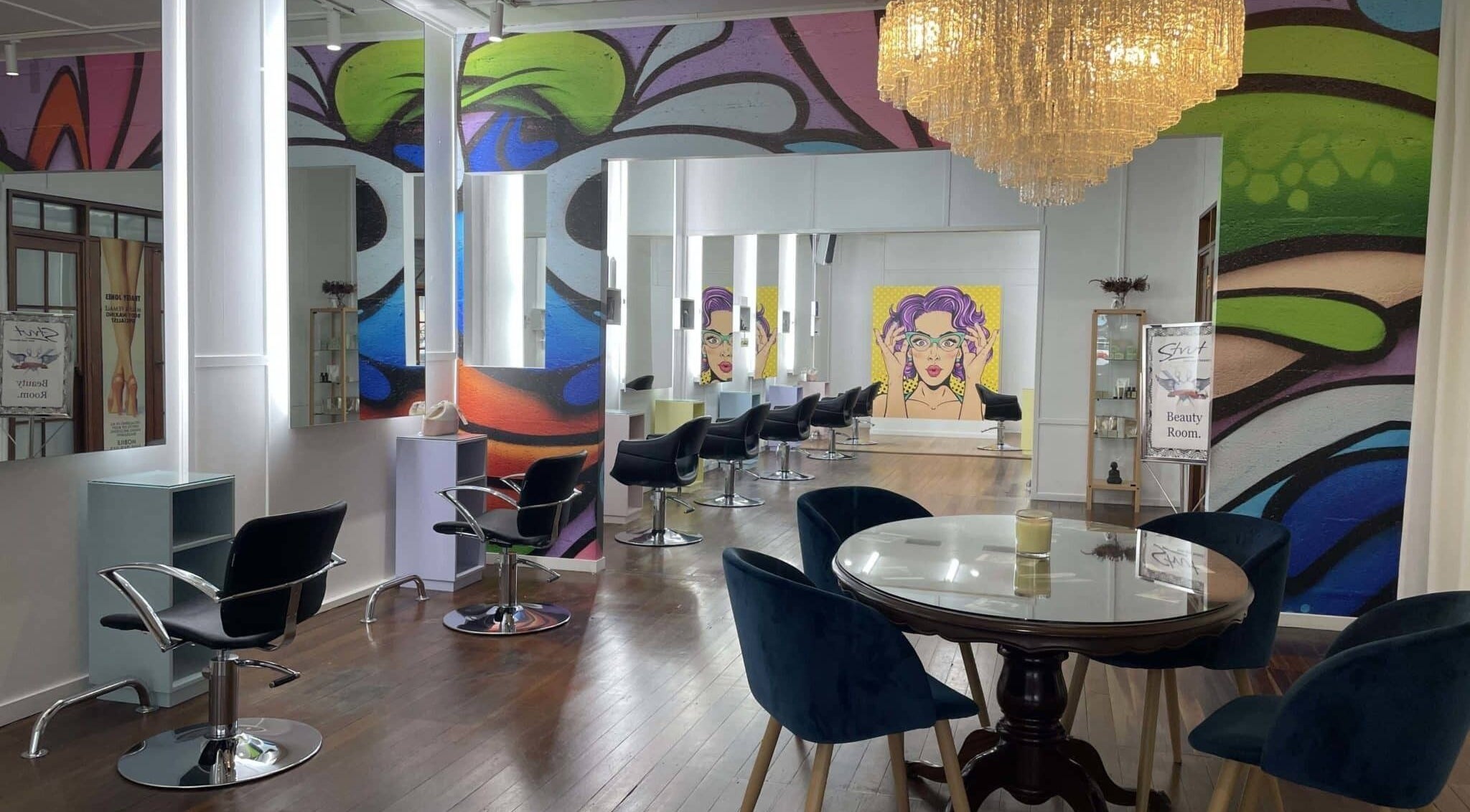 Chic interior of Strut Hair and Beauty, Maroochydore, Queensland, AU with colorful murals and modern decor.