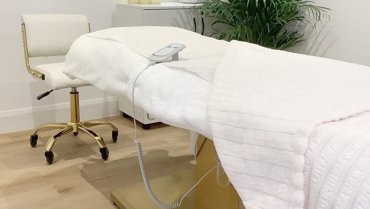 Massage table in a serene room at Blossom Leaf, Bognor Regis, England, GB, with a lush plant in the background.