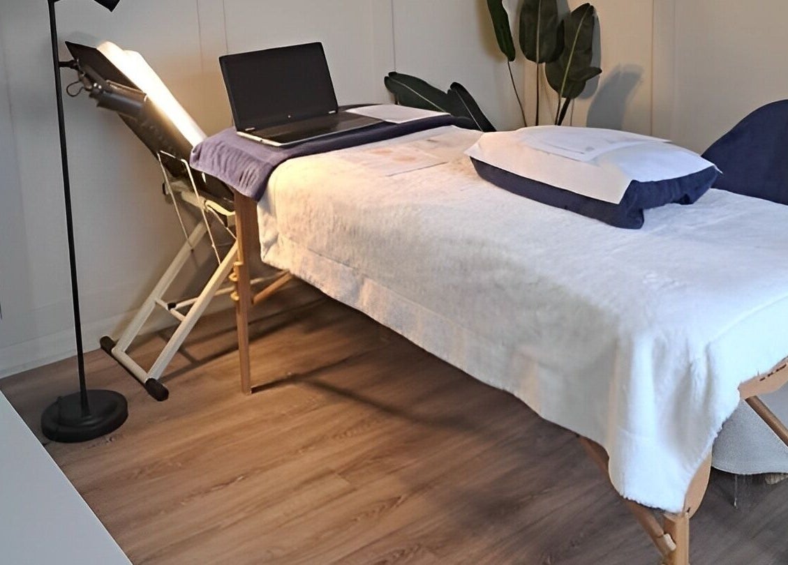 Calming therapy room at Blossom Leaf, Bognor Regis, England, GB, featuring massage table and laptop.