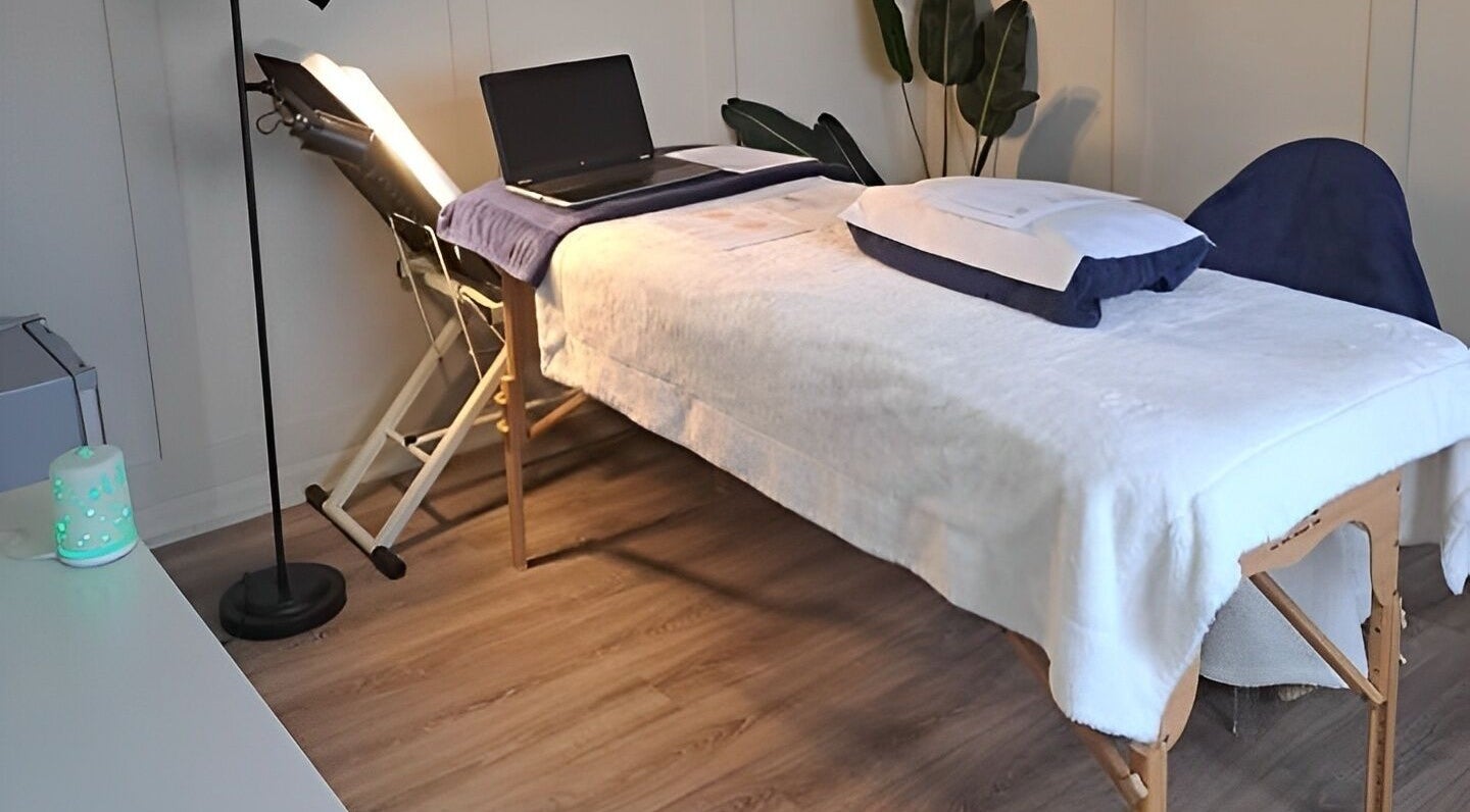Calming therapy room at Blossom Leaf, Bognor Regis, England, GB, featuring massage table and laptop.
