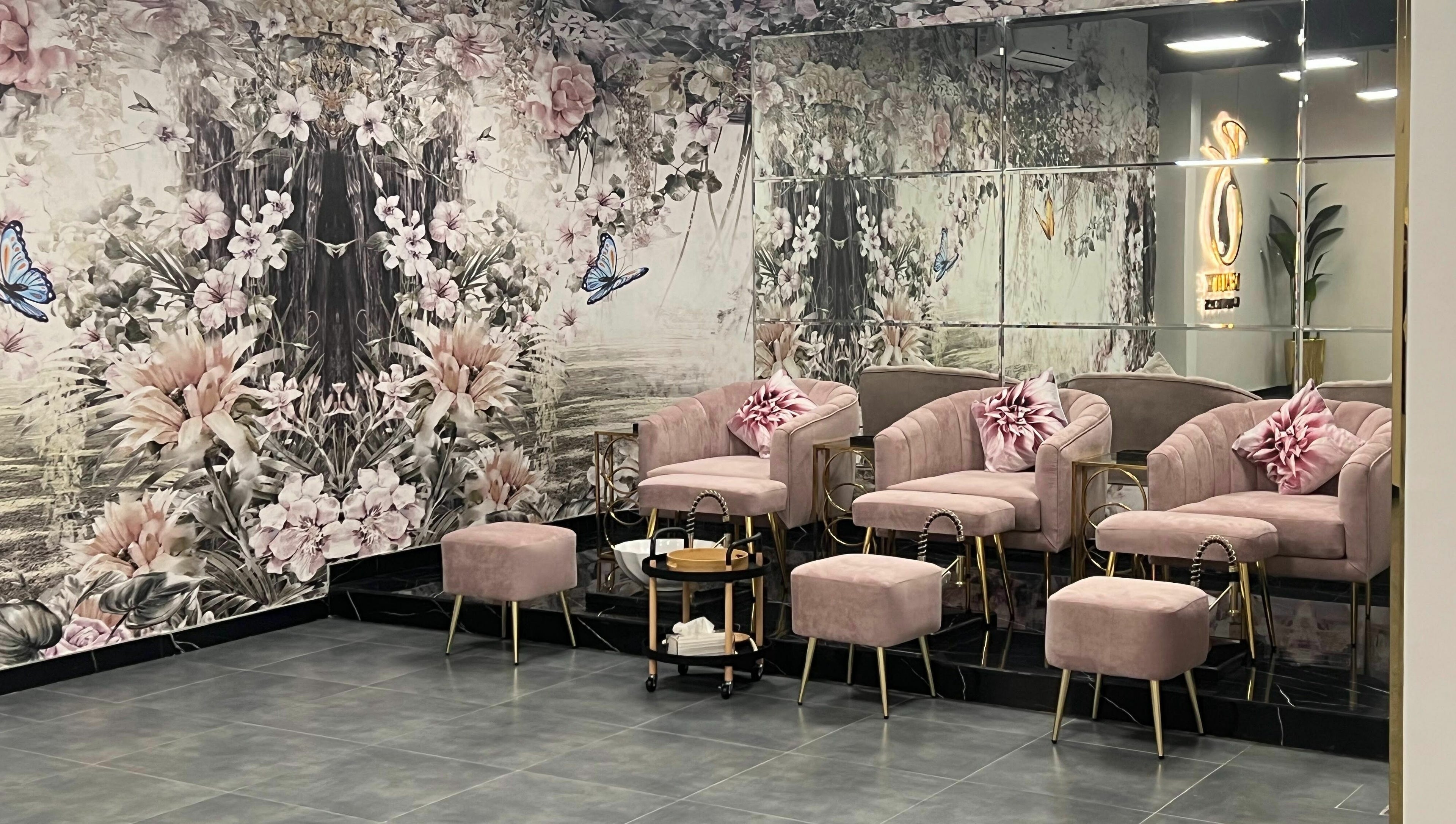 Elegant pink lounge at Beauty Owners, Riyadh, Riyadh Province, SA, with floral decor and mirrored walls.