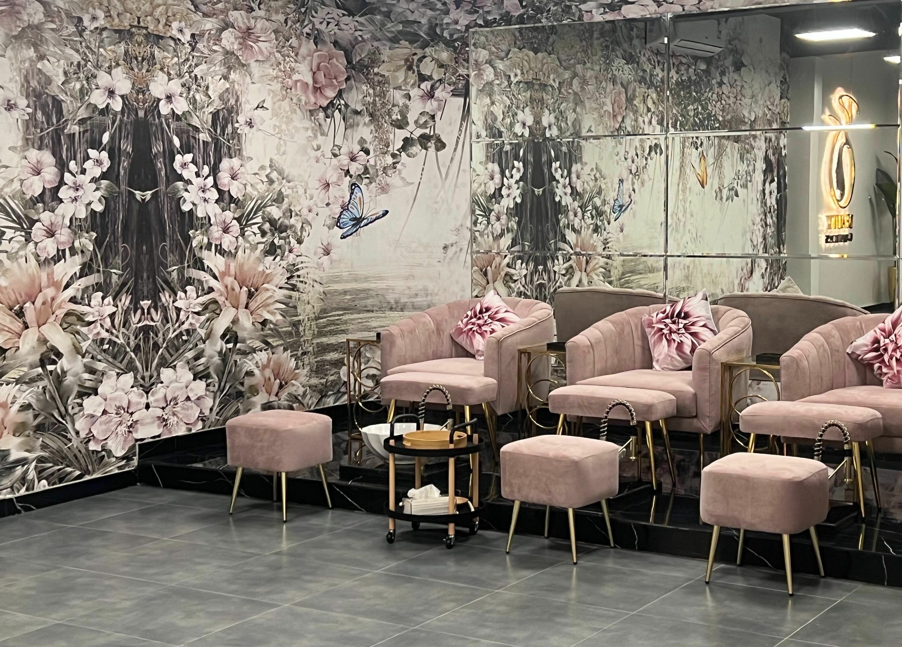 Elegant pink lounge at Beauty Owners, Riyadh, Riyadh Province, SA, with floral decor and mirrored walls.
