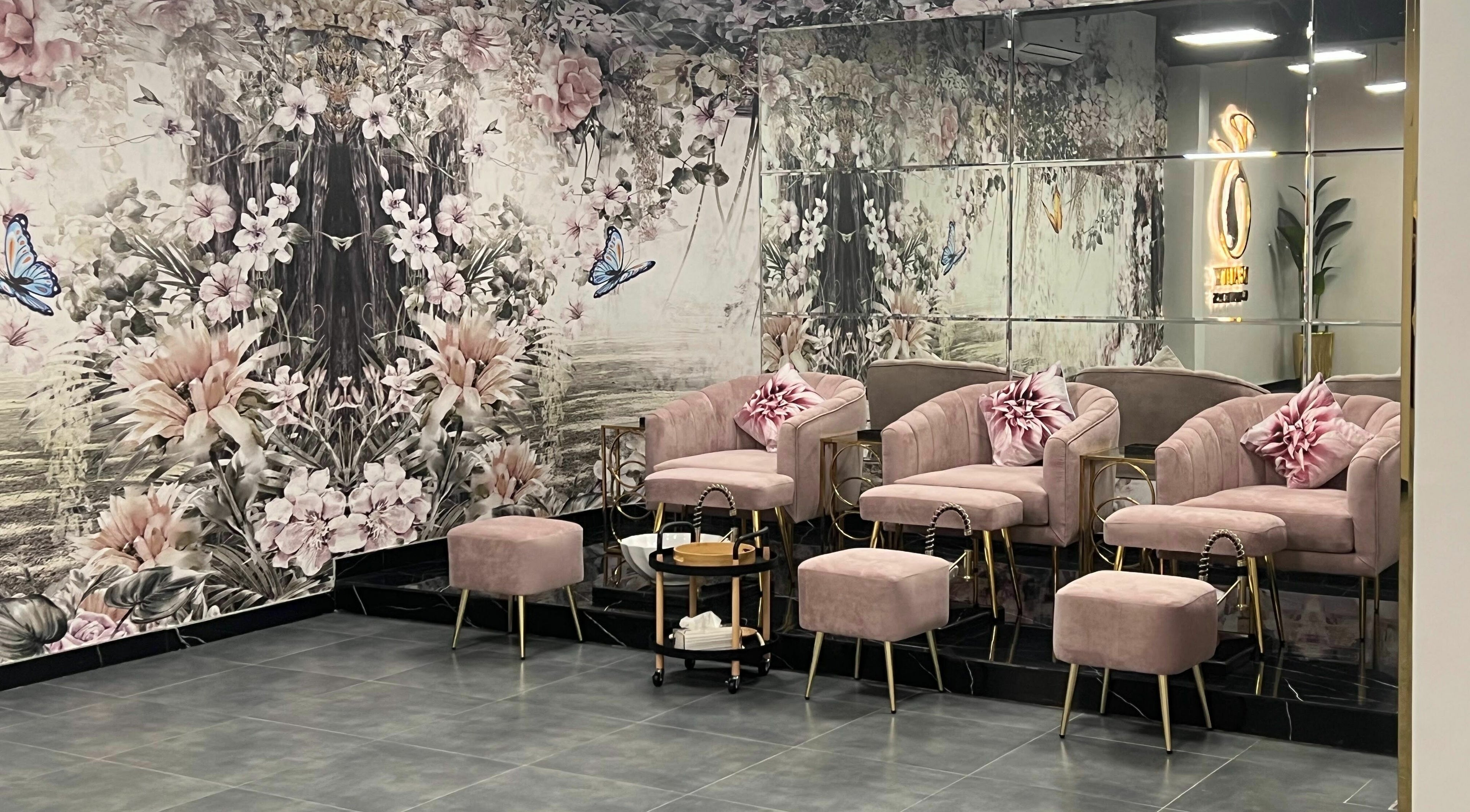 Elegant pink lounge at Beauty Owners, Riyadh, Riyadh Province, SA, with floral decor and mirrored walls.