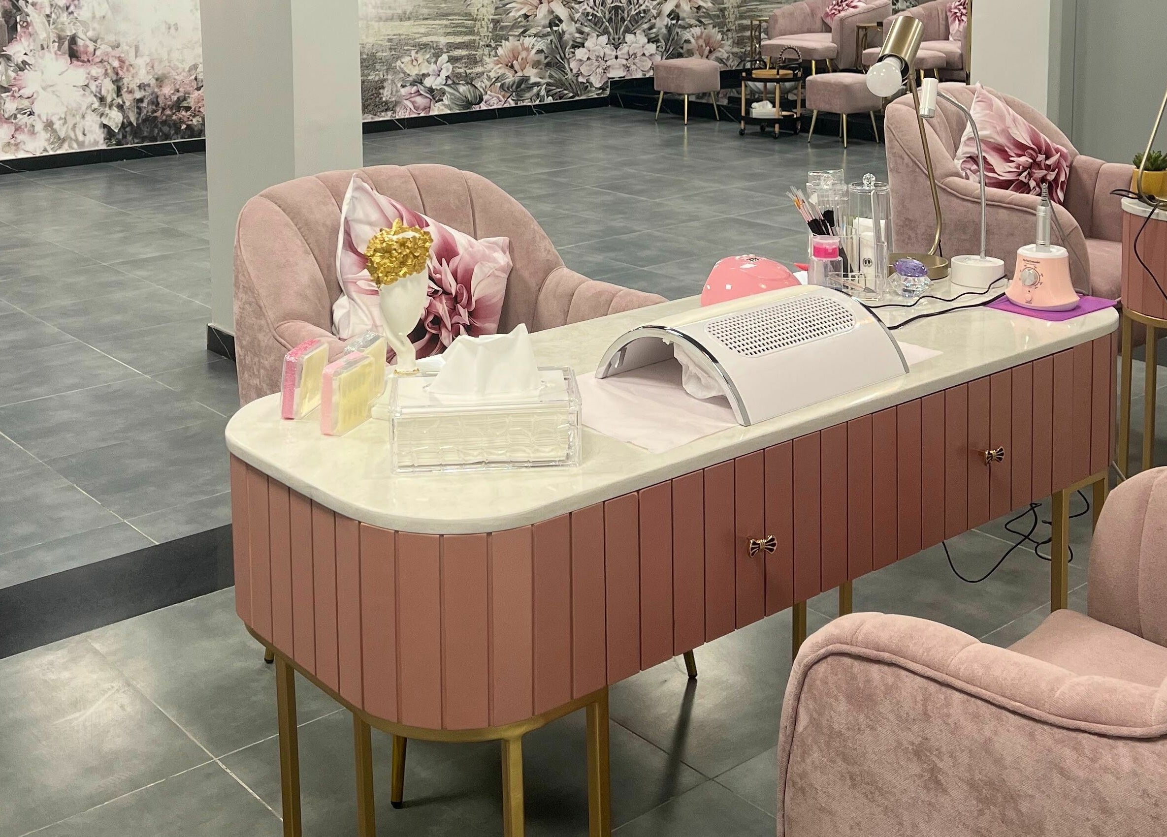 Chic nail salon interior at Beauty Owners, Riyadh, Riyadh Province, SA, featuring pink chairs and modern decor.