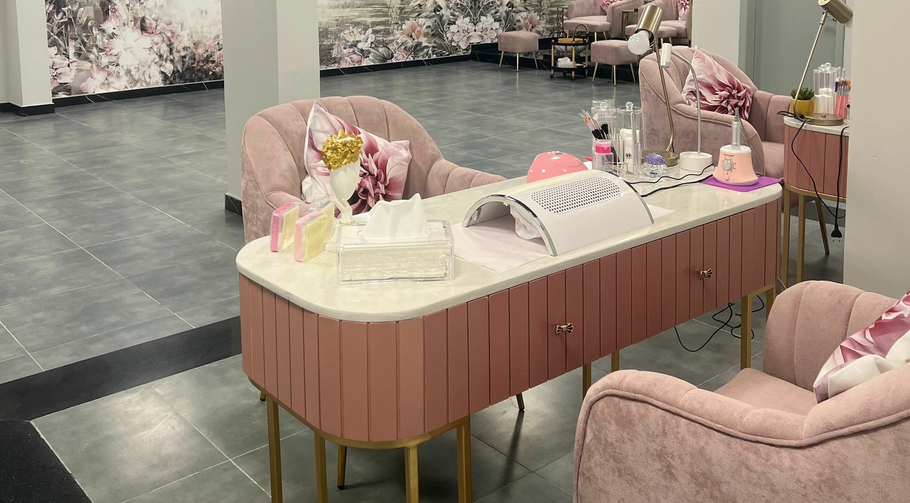 Chic nail salon interior at Beauty Owners, Riyadh, Riyadh Province, SA, featuring pink chairs and modern decor.