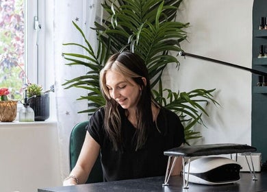 Bright workspace at Flos’ Beauty Box in Stroud, England, GB with a plant and beauty products on display.