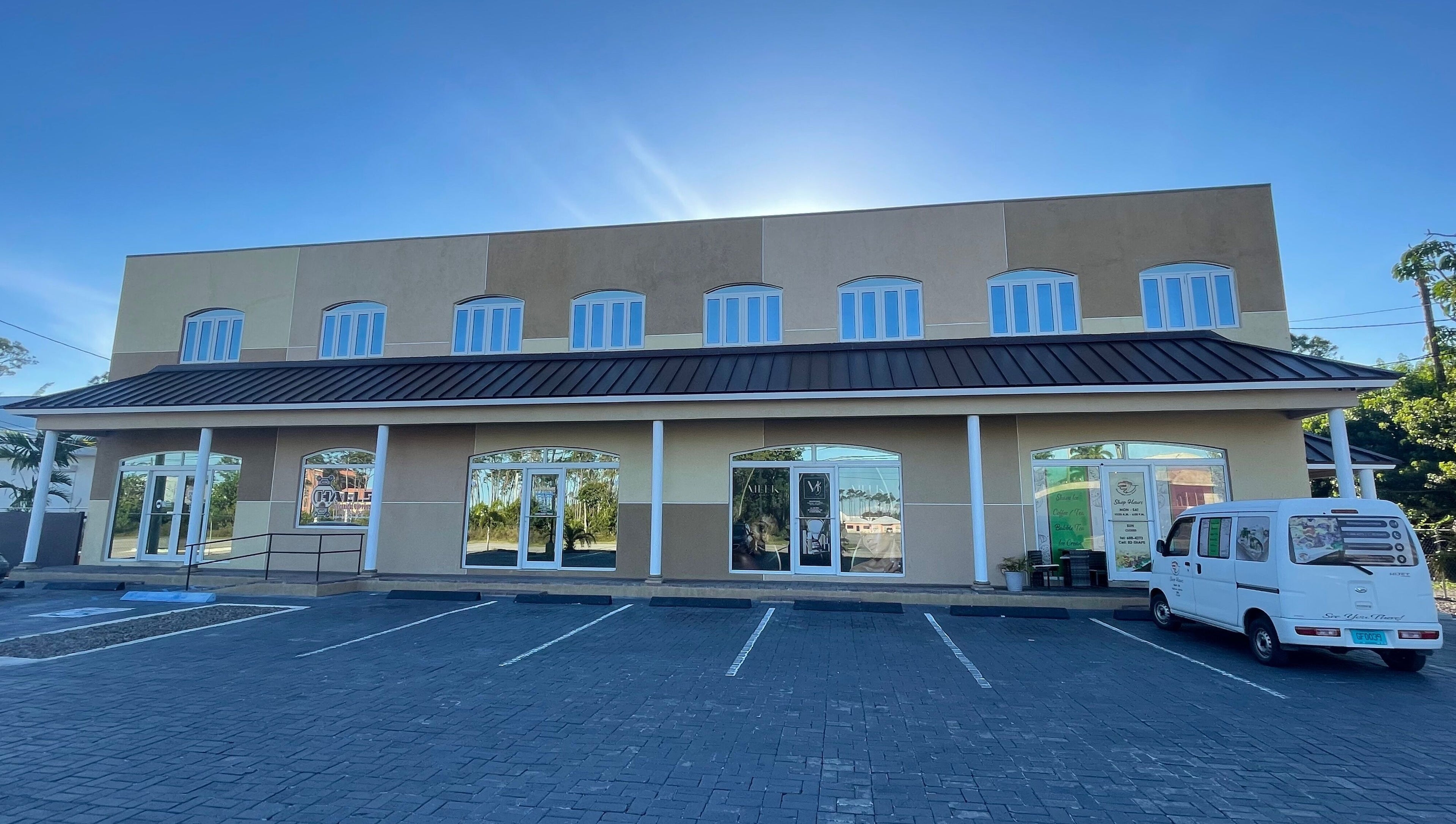 Exterior of Meek Beauty salon in Freeport, Freeport, BS with a sunny backdrop and parking area.