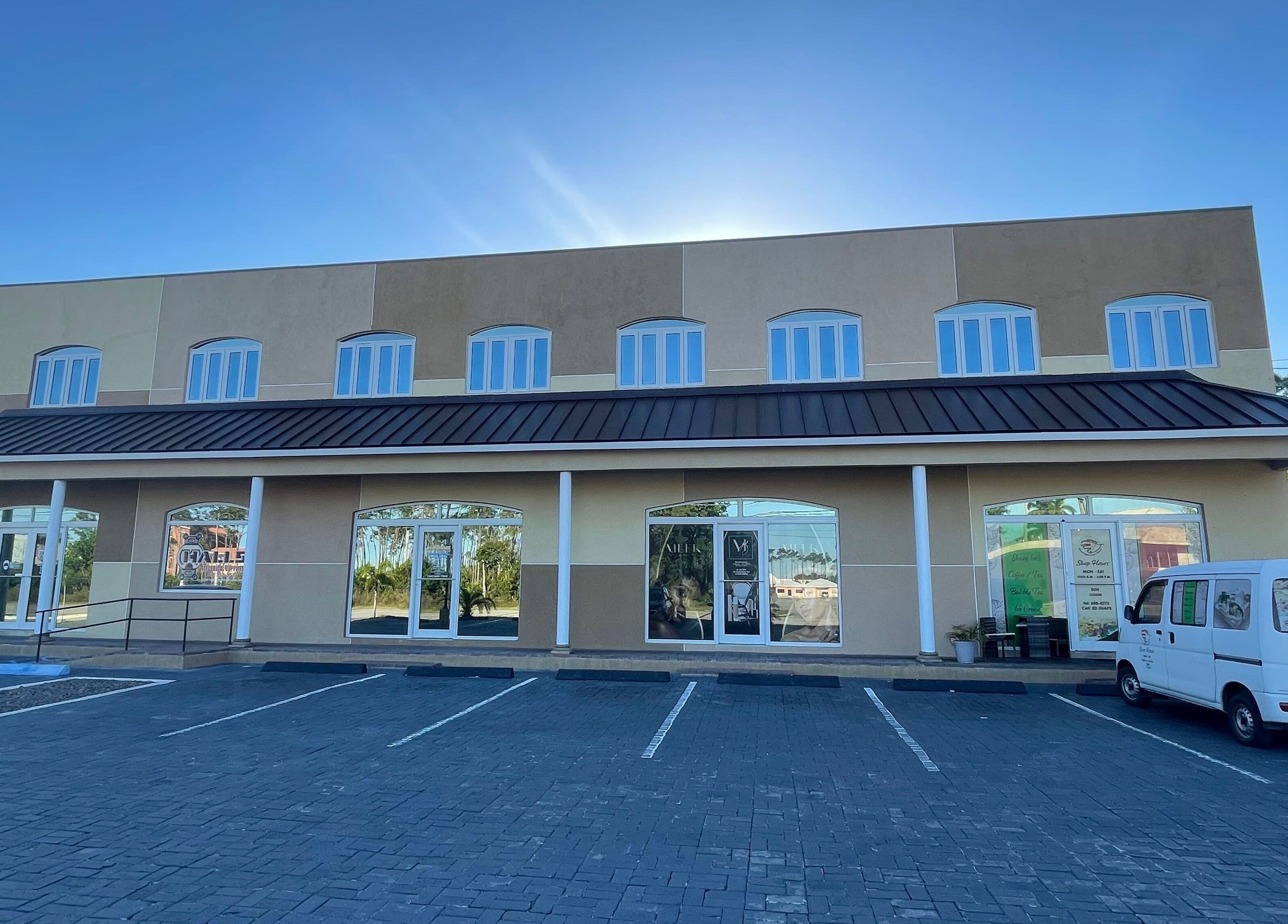 Exterior of Meek Beauty salon in Freeport, Freeport, BS with a sunny backdrop and parking area.