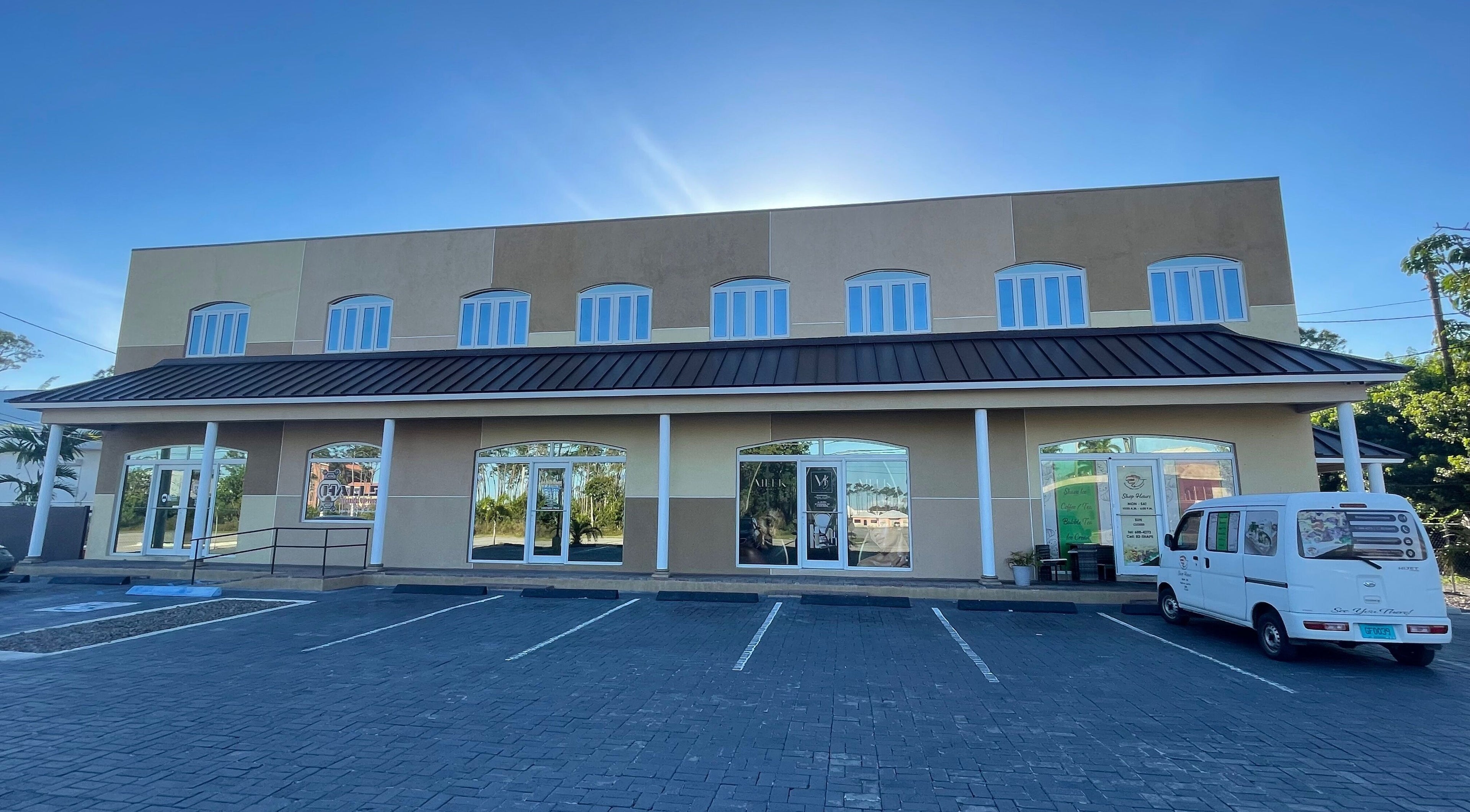 Exterior of Meek Beauty salon in Freeport, Freeport, BS with a sunny backdrop and parking area.