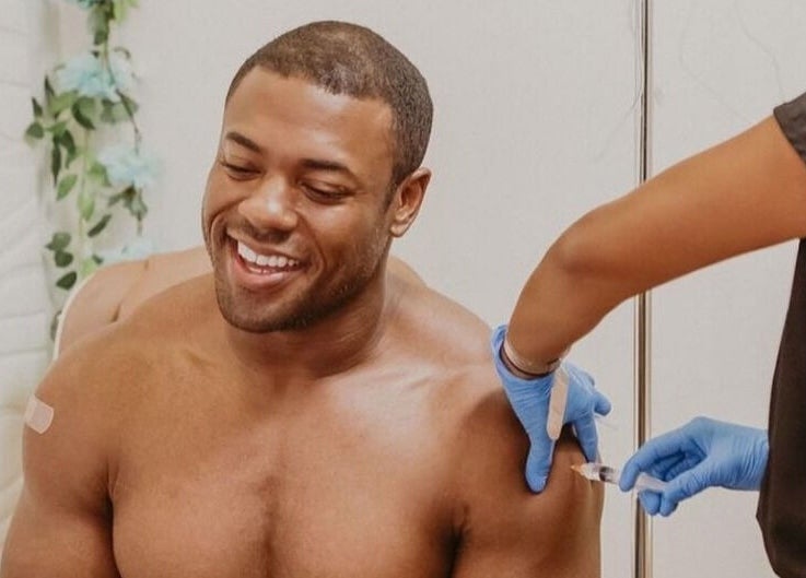 Smiling man receives vitamin injection at Trio Pilates Vitamin Injection Pop up in Bridgewater, Massachusetts, US.