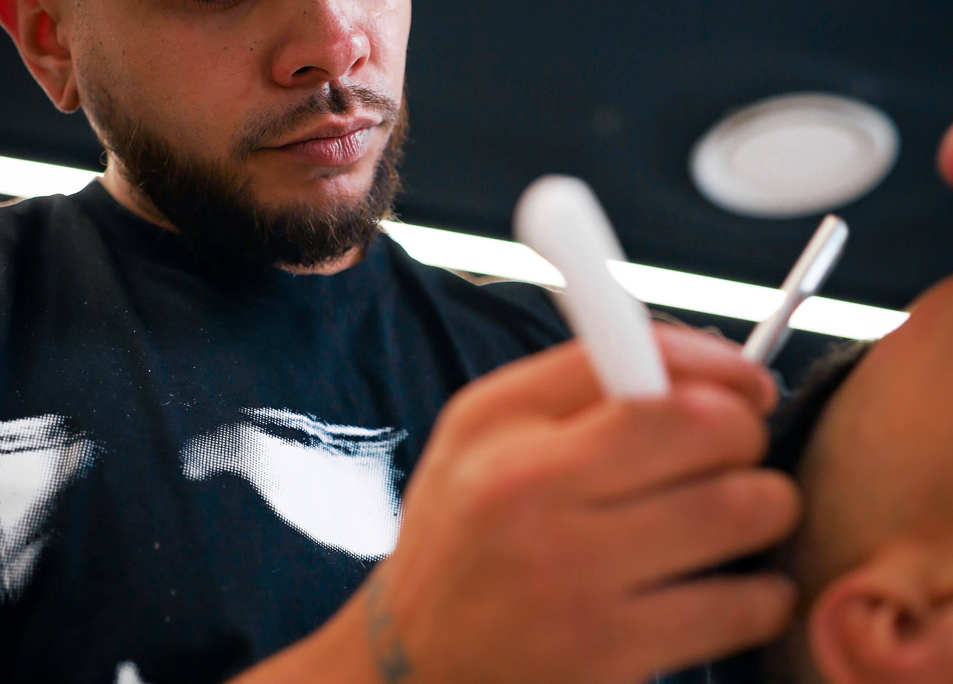 Barber at Eleven 11 Barber Studios, Coomera, Queensland offering precision shave service to client.