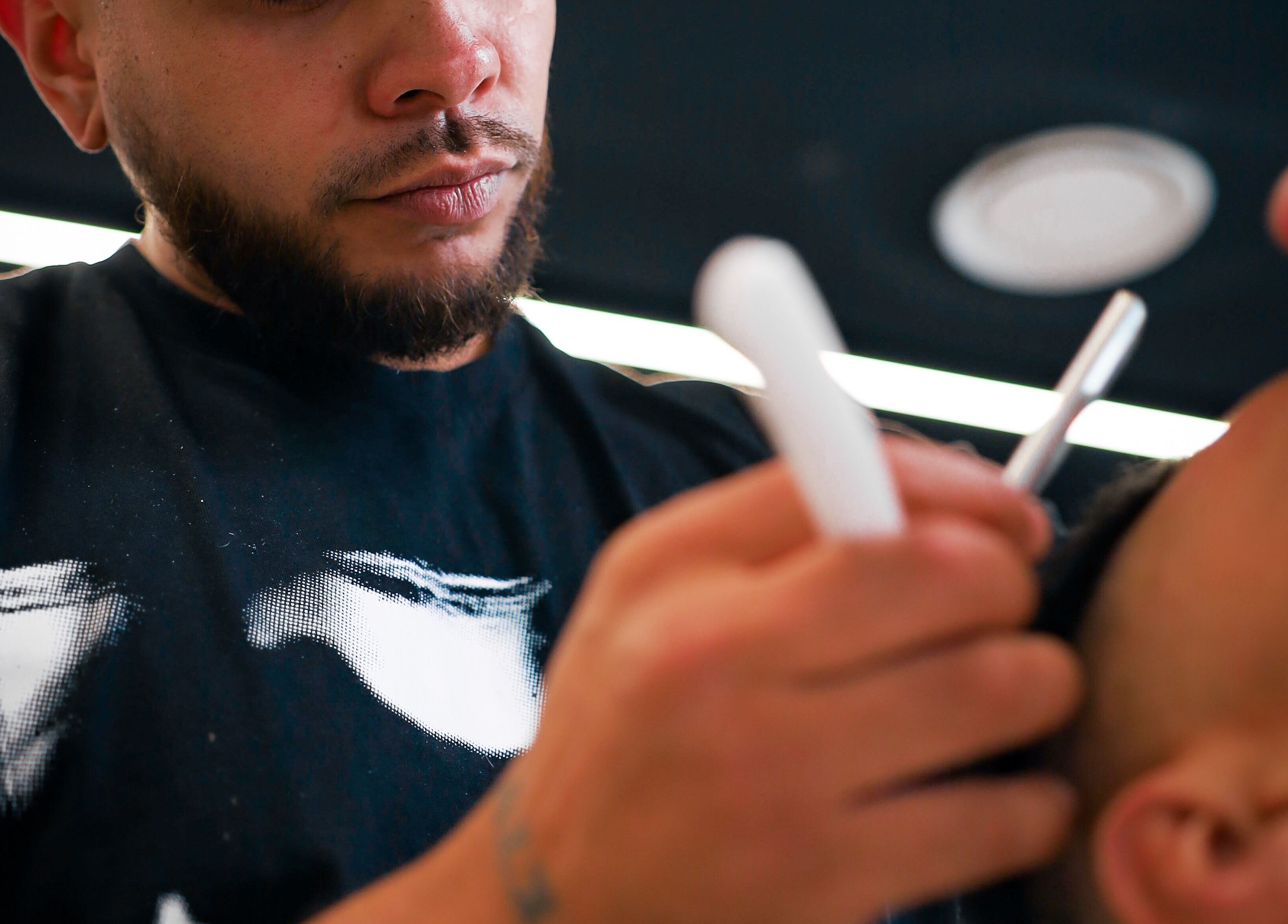 Barber at Eleven 11 Barber Studios, Coomera, Queensland offering precision shave service to client.