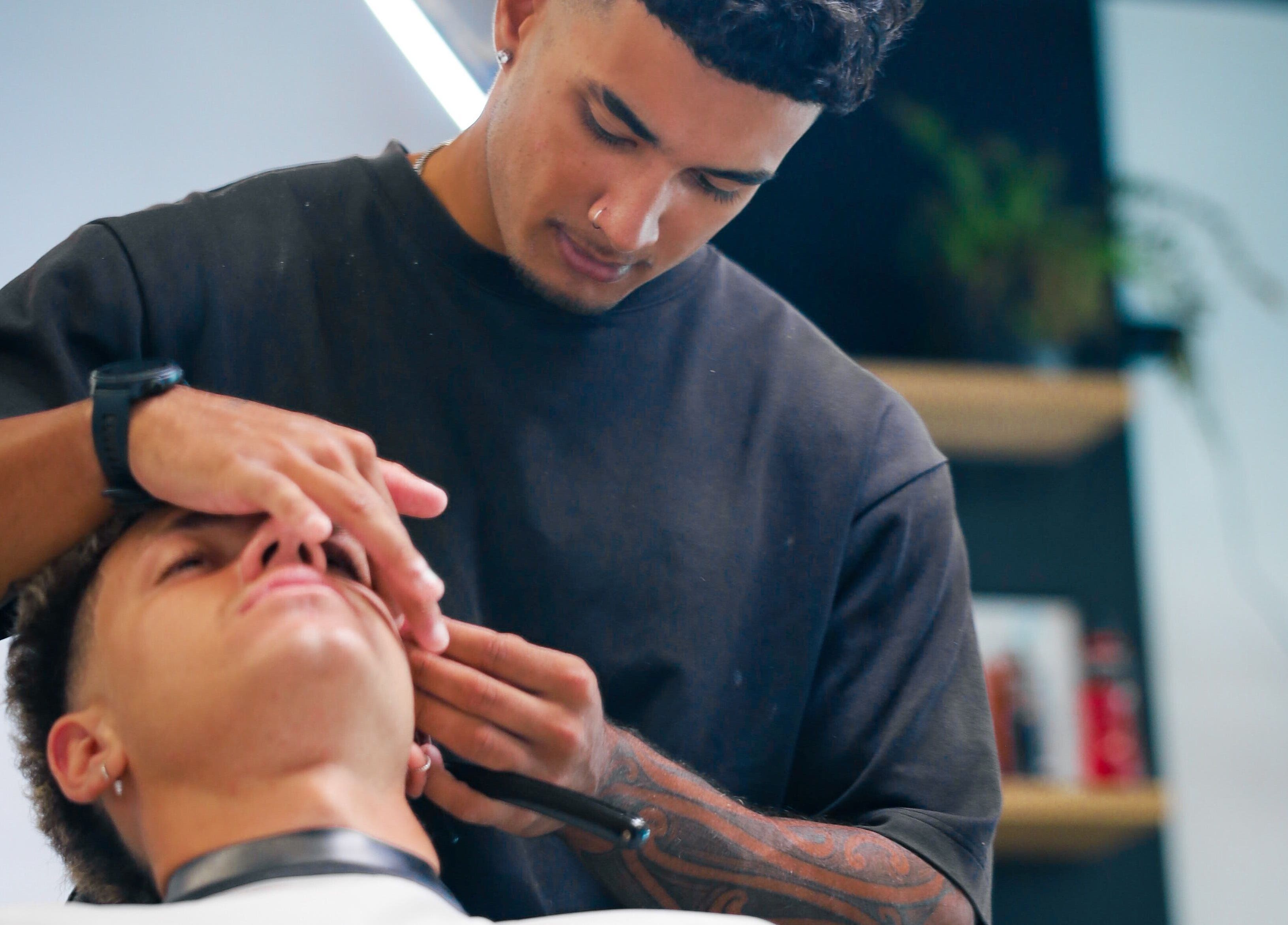 Barber at Eleven 11 Barber Studios in Coomera, Queensland, AU, expertly trimming a client's beard.