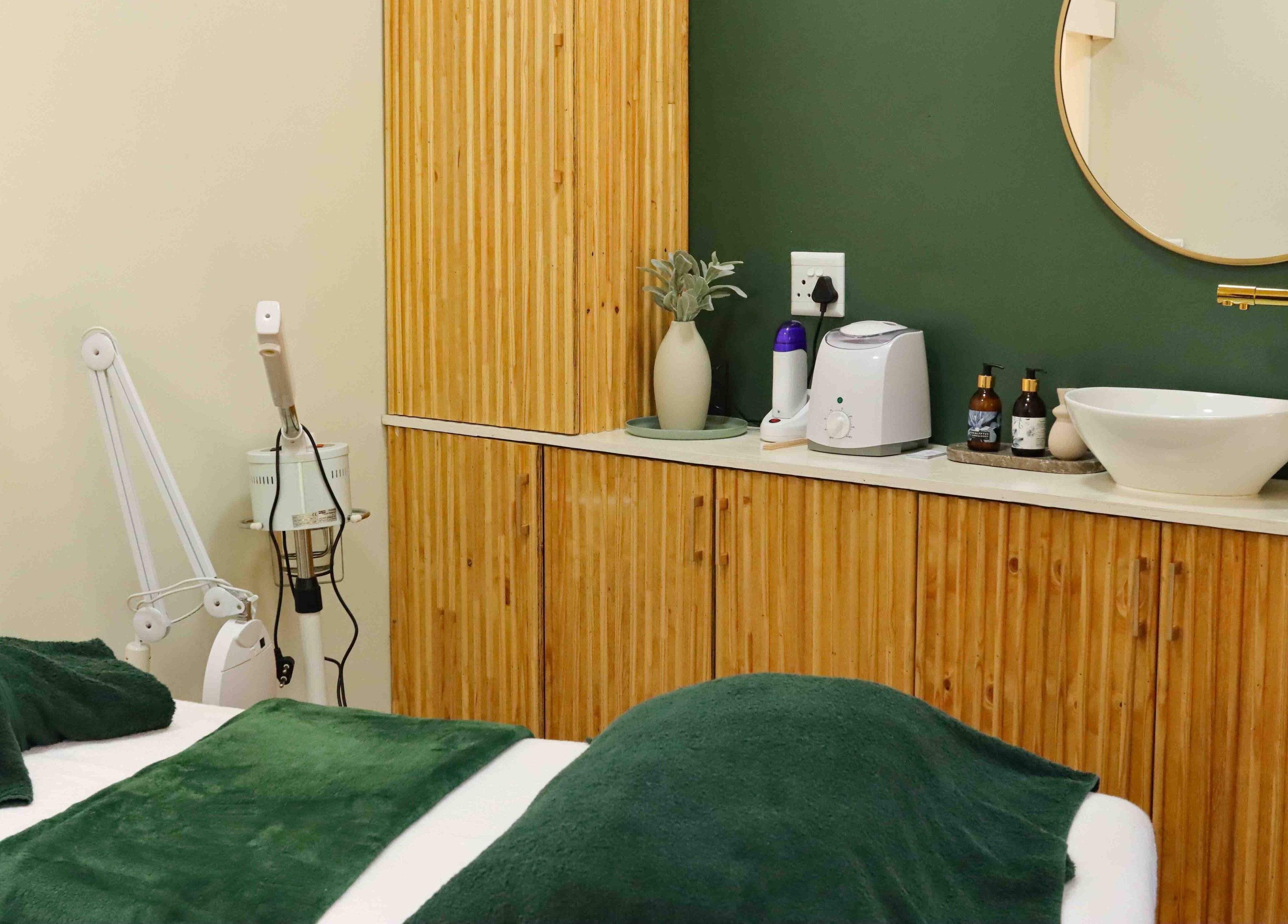 Relaxing treatment room at Umdlalo Wellness, Port Shepstone, Kwazulu-natal, ZA with green accents and modern fixtures.