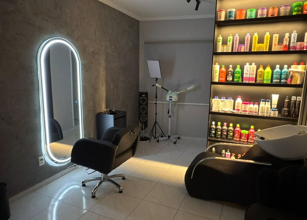 Interior moderno do salão Dani Manja Cabelos em São Paulo, com espelho iluminado e prateleira de produtos.