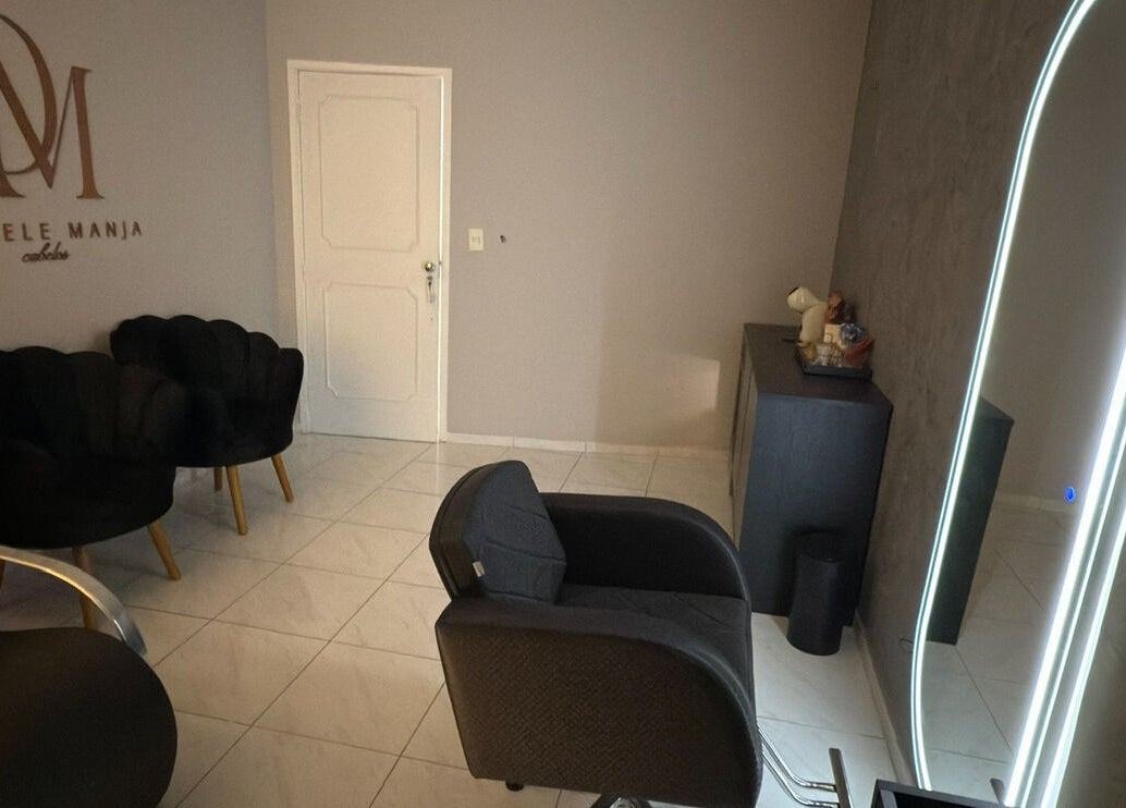 Elegante área interna da Dani Manja Cabelos em São Paulo, São Paulo, BR, com cadeiras e espelho iluminado.