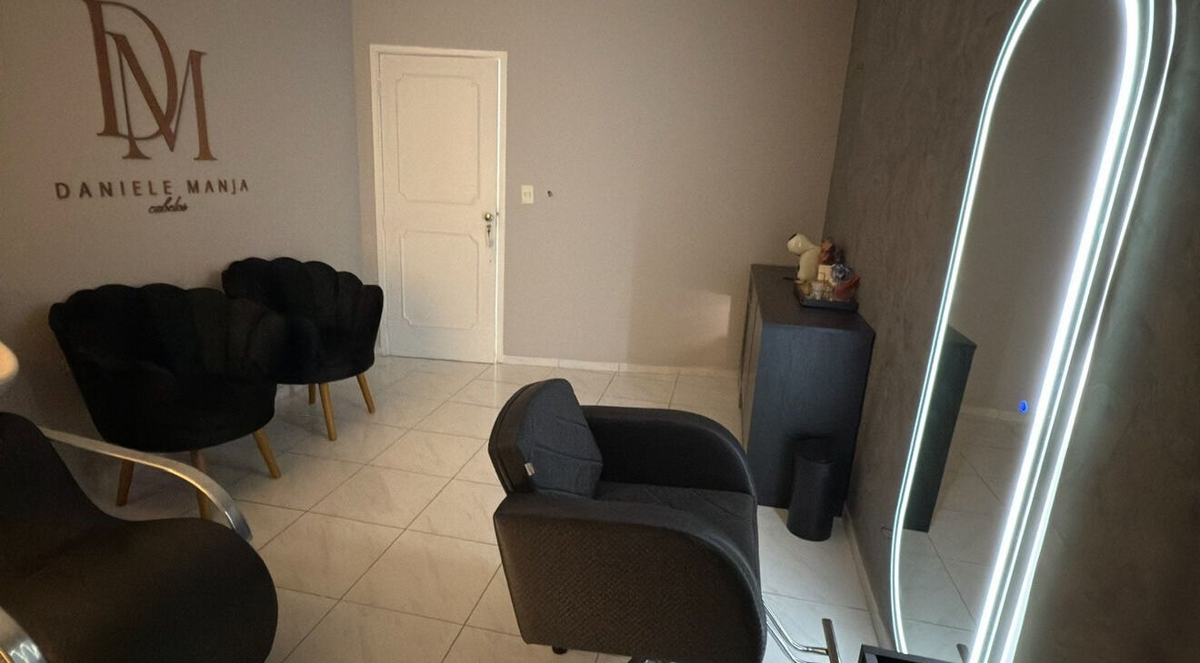 Elegante área interna da Dani Manja Cabelos em São Paulo, São Paulo, BR, com cadeiras e espelho iluminado.