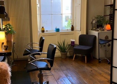 Chic interior of The Hair Artist in Dublin, County Dublin, IE with sleek chairs and ambient lighting.