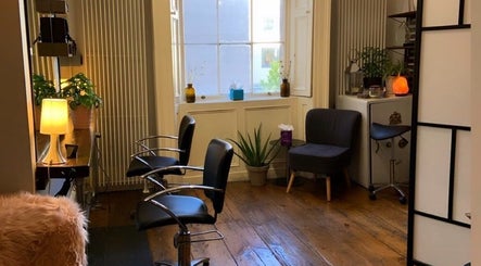 Chic interior of The Hair Artist in Dublin, County Dublin, IE with sleek chairs and ambient lighting.