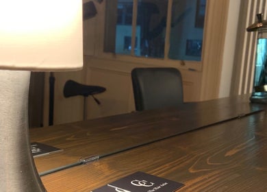 A warm, inviting table lamp on a wooden counter at The Hair Artist, Dublin, County Dublin, IE.