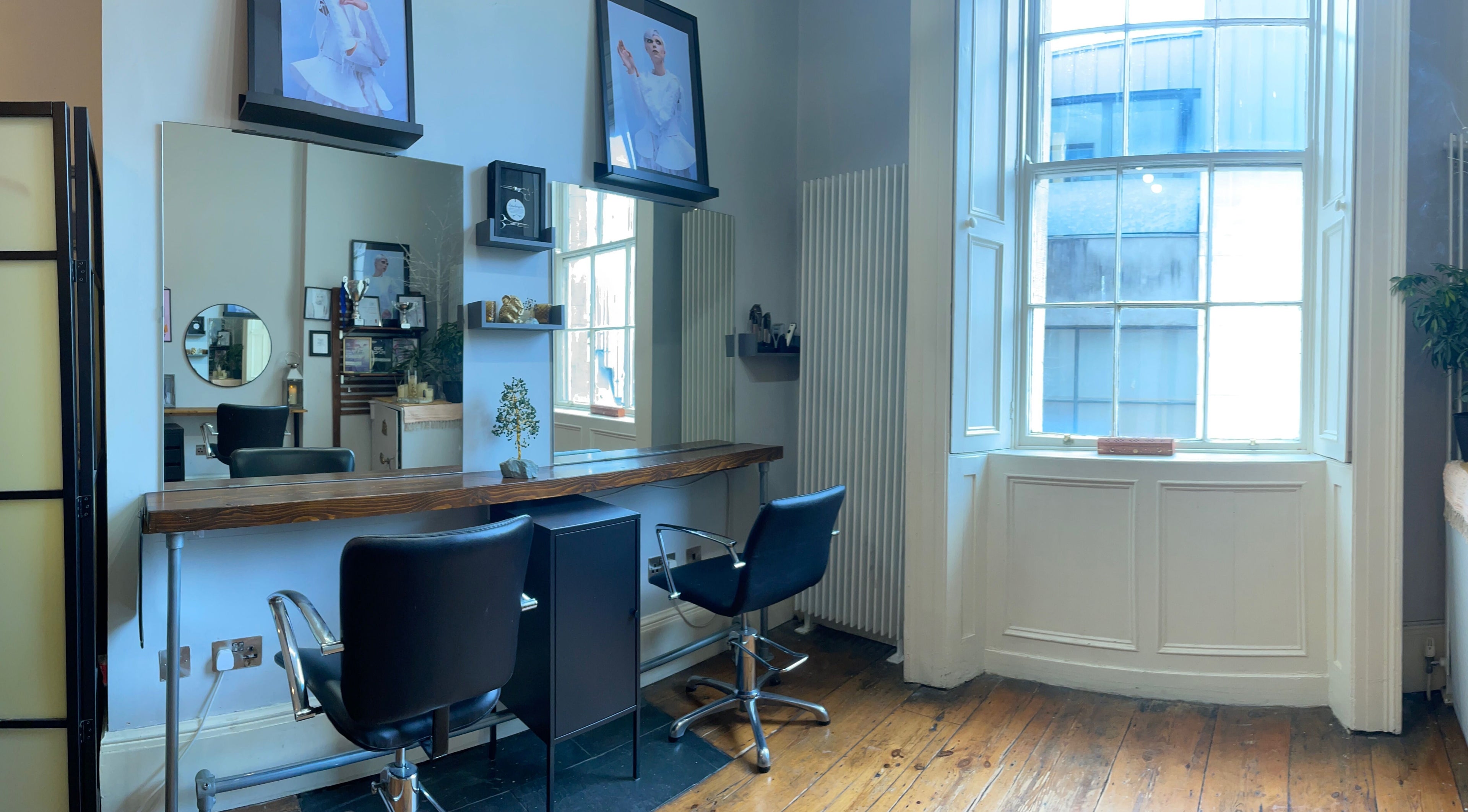 Elegant salon setup at The Hair Artist in Dublin, County Dublin, IE featuring modern chairs and large mirrors.