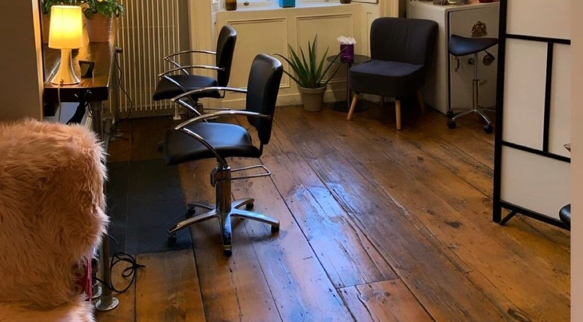 Inviting salon interior at The Hair Artist, Dublin, County Dublin, IE with modern chairs and ambient lighting.