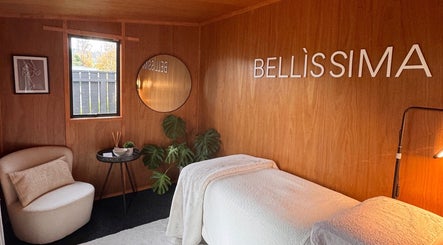 Relaxing spa room at Bellissima Beauty, Waikanae, Wellington, NZ with warm wooden decor and cozy seating.